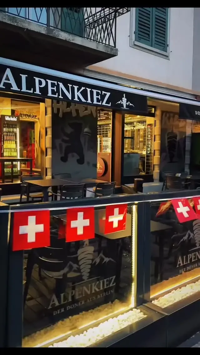 Alpenkiez an der Regensbergstrasse am Abend, mit Schweizer Fähnchen an der Terrasse