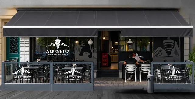 Alpenkiez von aussen: Markise, Terrasse und Glas-Windschutz an der Regensbergstrasse