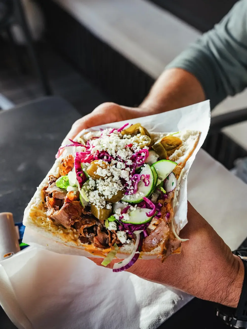 Frisch belegter Alpenkiez-Döner im Fladenbrot mit Rotkraut, Gurke, Peperoni und Feta
